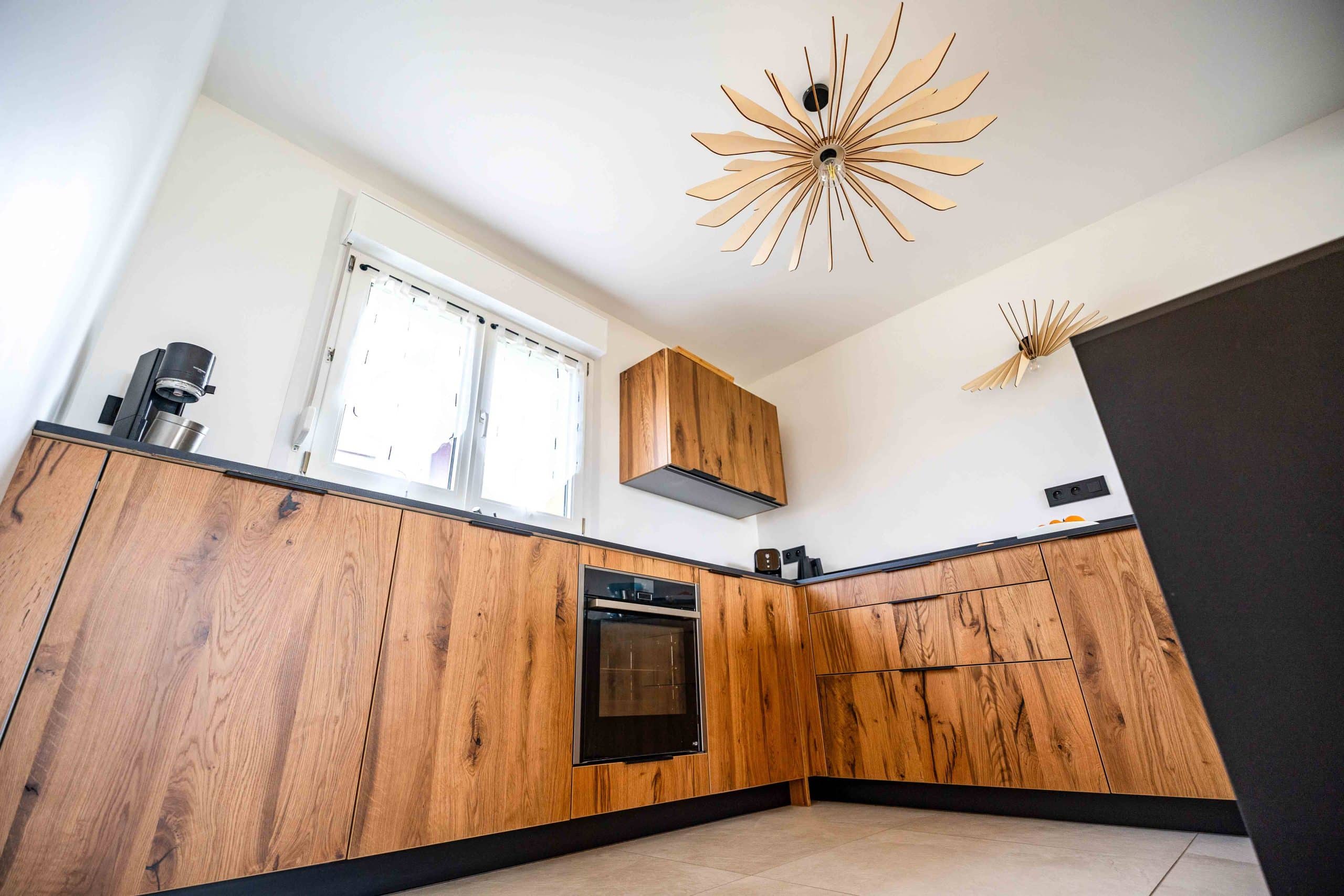 Cuisine contemporaine en bois clair et noir avec luminaires design – rénovation d’une maison des années 2000 par Aléna Zuliani – Azai architecture.